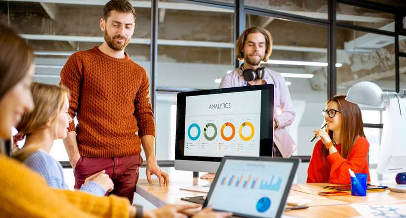 Profissionais em reunião no escritório com computador sob a mesa.