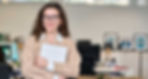 Estudante com notebook na mão e um escritório.