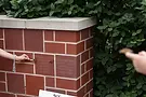 Brick wall with two hands holdinging butterflies