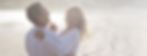 A joyful couple dressed in white, dancing and laughing on a serene beach at sunset, embodying intimacy, connection, and bliss.