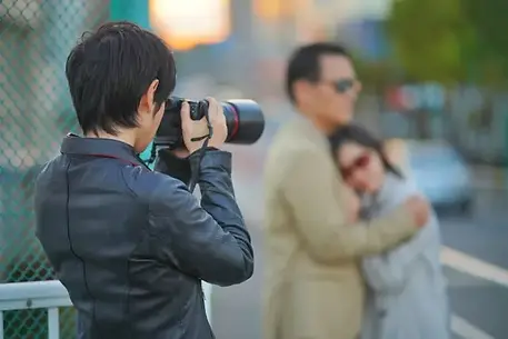 不貞の証拠を撮影する調査員