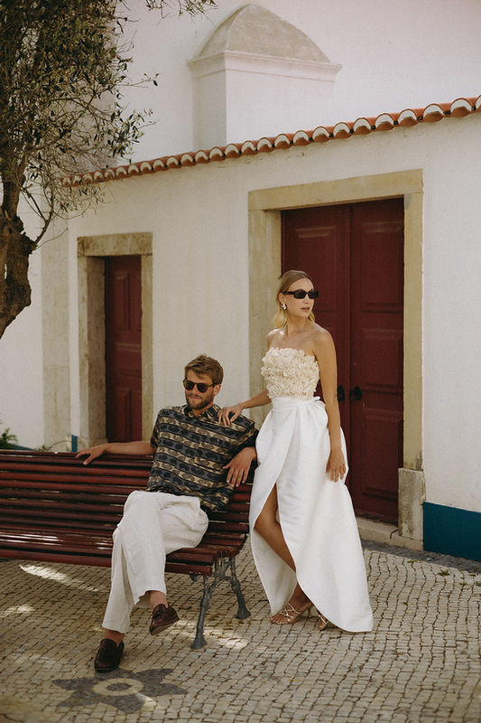 Stylish modern wedding couple walking in Ericeira Portugal, coastal destination wedding, contemporary bridal fashion