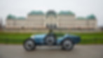 Classic blue Bugatti Type-style car parked in front of a historic palace, photographed for Rennauto Brisbane.