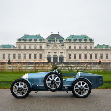 Blue Bugatti Type-style collector car photographed in front of a historic palace for Rennauto Brisbane.