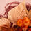 Thumbnail: orange painted palm spears next to orange flowers