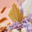 Thumbnail: painted yellow palm spears next to lilac flowers