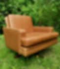 En designklassiker lenestol med svingfunksjon trukket i cognac farget skinn
