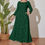 Thumbnail: Plus size model wearing stunning emerald green colored dress adorned with silver and golden stars