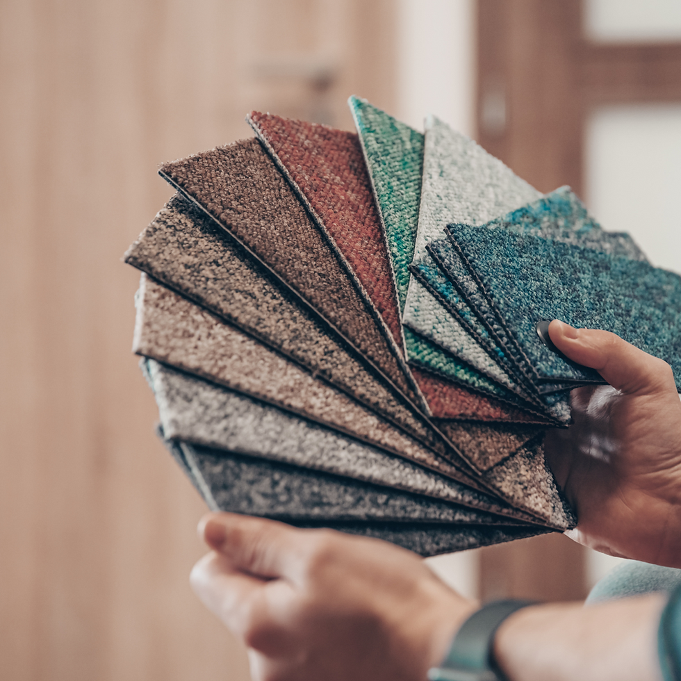 someone holding 12 different colored carpet samples in their hands
