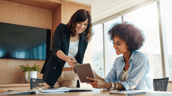 Two business women looking at a tablet with business intelligence software
