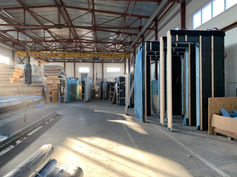 Interior view of a modular construction facility with finished wall modules and timber materials.