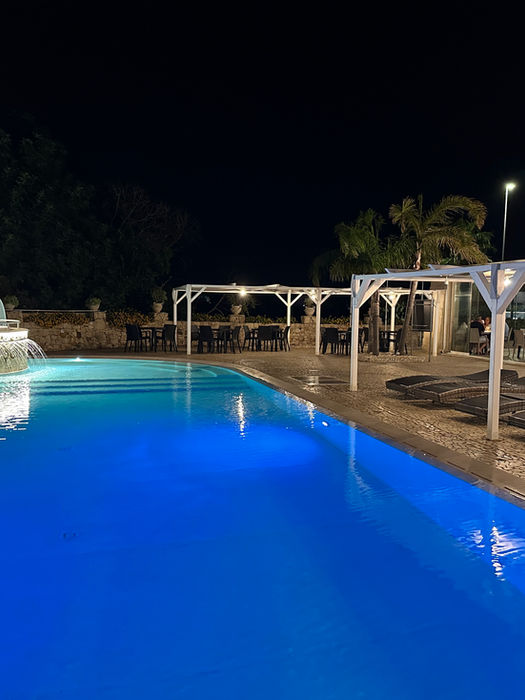 Vista notturna della piscina del Toto residence con lettini a pagamento, servizio accessorio del La Casetta di Gisel, casa vacanze per coppie a Nardò.