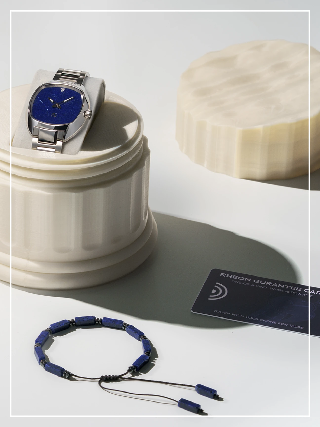 Rheon watch and Greek inspired packaging that looks like an Ancient column