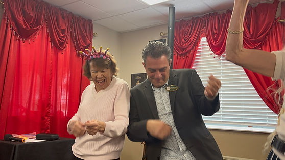 Executive Director and Smiling Resident Playing Air Guitar During Birthday Bash