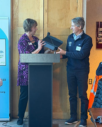 Marie Oliva Chamber President & CEO presenting 2025 Business of the Year Award to Rob Bateman CFO and Interim CEO of OpenCape