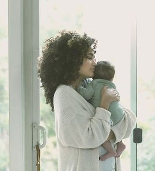a doula standing and holding a newborn infant