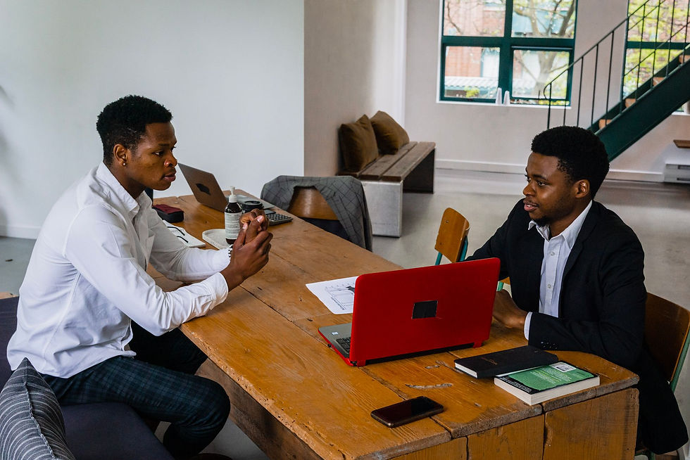 Two men in a small office meeting with laptops, deciding whether they need an MSP for cyber insurance