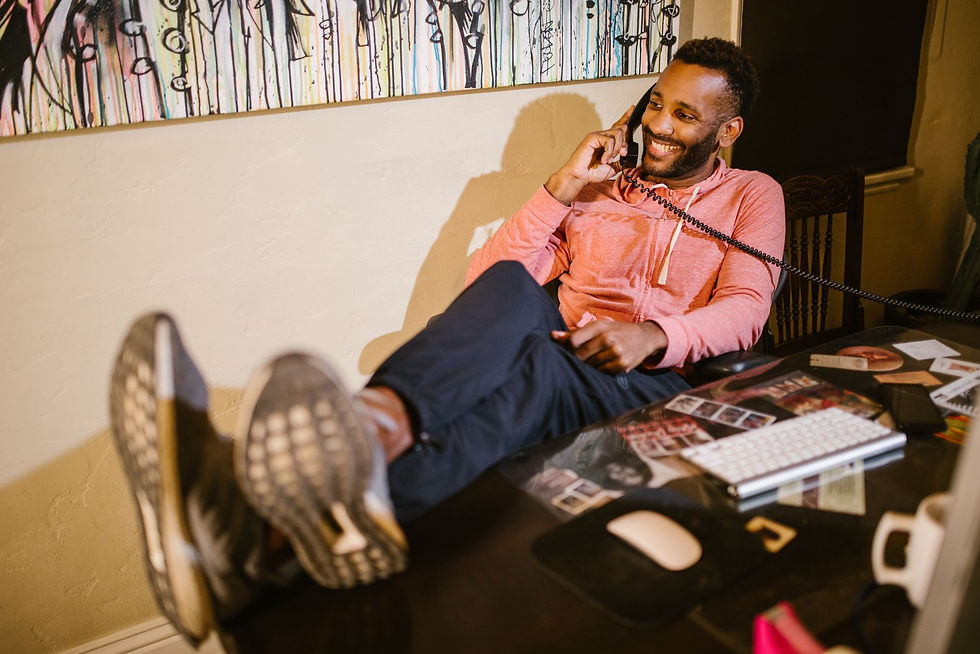 Smiling man on a phone call at his desk, calling for help with cyber insurance requirements