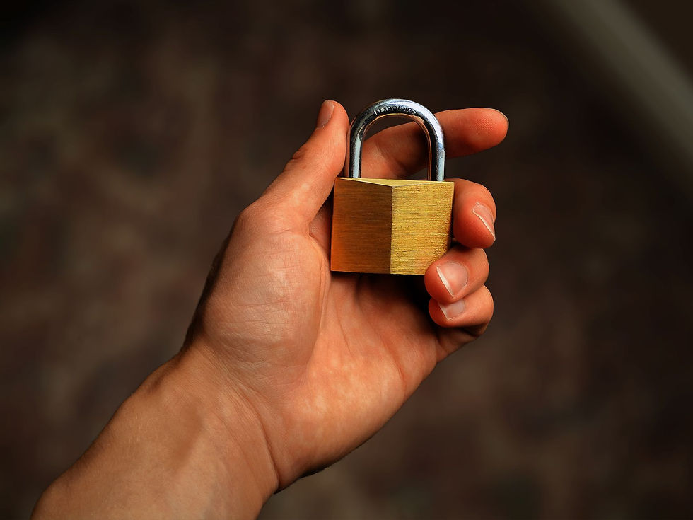 Hand holding a brass padlock, showing that real security goes beyond passing the insurance application