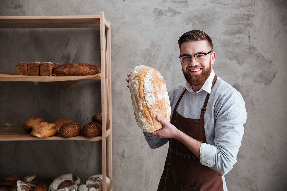 cheerful-young-man-baker-standing-bakery-holding-bread.jpg