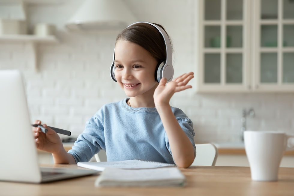 Smiling little Caucasian girl in headphones have video call distant class with teacher usi