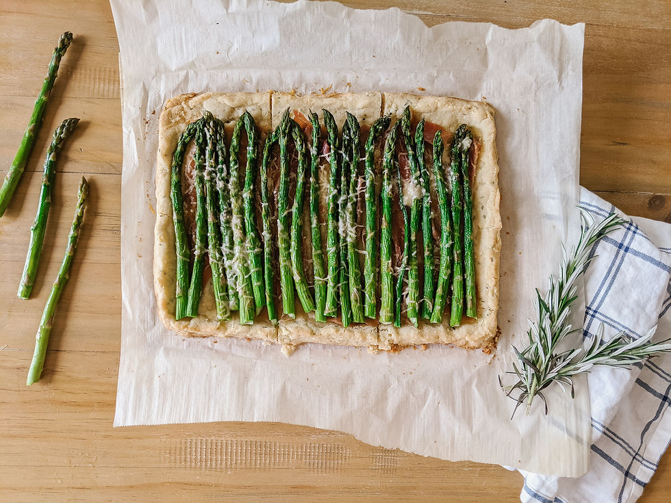 An overhead view of a rectangular shaped asparagus and prosciutto tart. It's cut into six equal pieces.