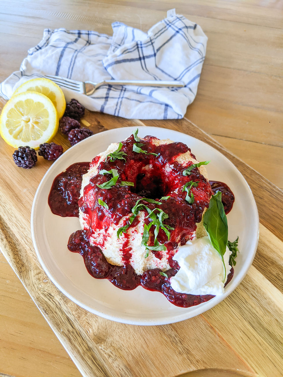 Full Paleo Angel Food Cake is shown with a dark, blackberry and basil compote
