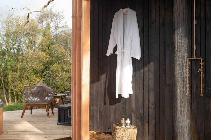 Modern exterior shower leading to deck and hot tub 