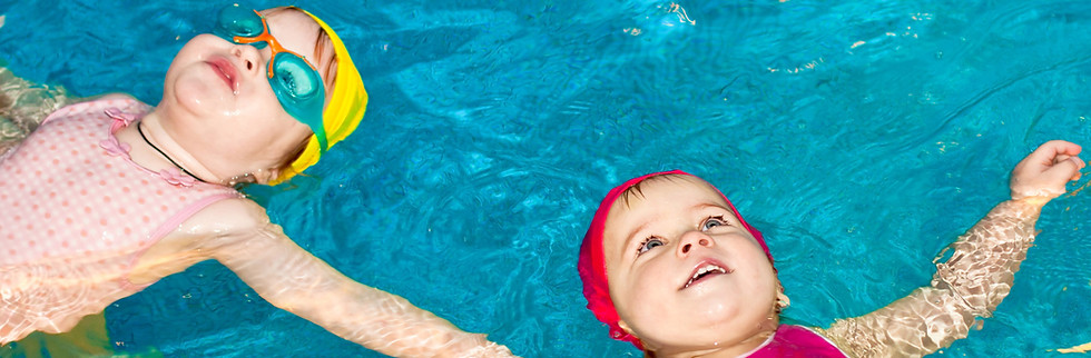 Kinder leigen im Wasser auf dem Rücken