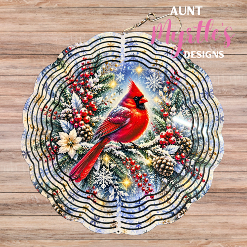 Wind spinner featuring a red cardinal perched on snowy evergreen branches with red berries, pinecones, and snowflakes.