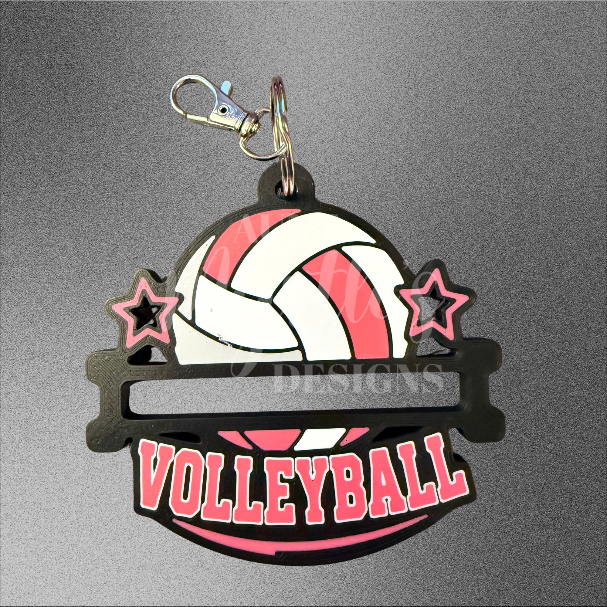 Black hair tie holder keychain with a pink and white volleyball, stars, and “VOLLEYBALL” lettering.