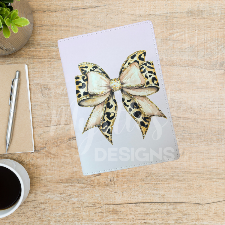 A5 journal featuring a leopard-print bow with gold accents on a soft pink ombré background.