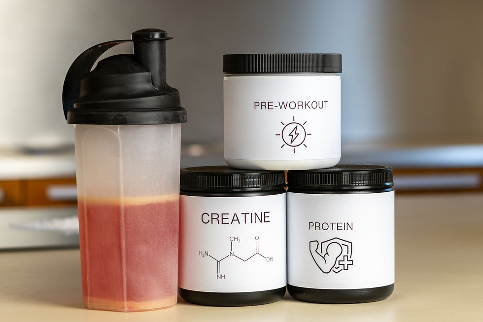 A shaker bottle next to a tubs of protein powder, pre-workout, and creatine