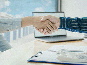 Two people shaking hands, self-storage units can be viewed from the window.