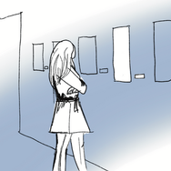 Woman stands and stares at hanging art piece on the wall