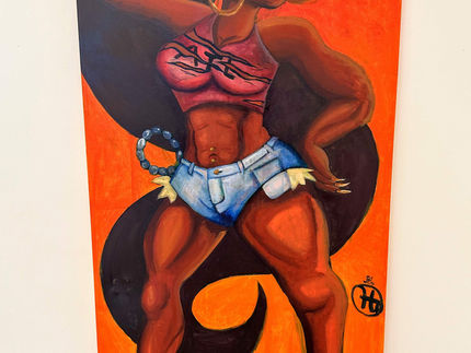 A brown skinned woman with long black hair in a pony tail swirling behind her. The figure wears a red tiger cut crop top shirt with the letter ATL across the breast. Complimented by blue jeans shorts with an attached blue beaded chain. On her pointed feet she wears golden ballet pointe shoes. The figure has a orange background and stands on a gradient blue floor. 