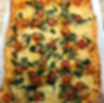 Trozo de pizza de tomate con queso y rúcula