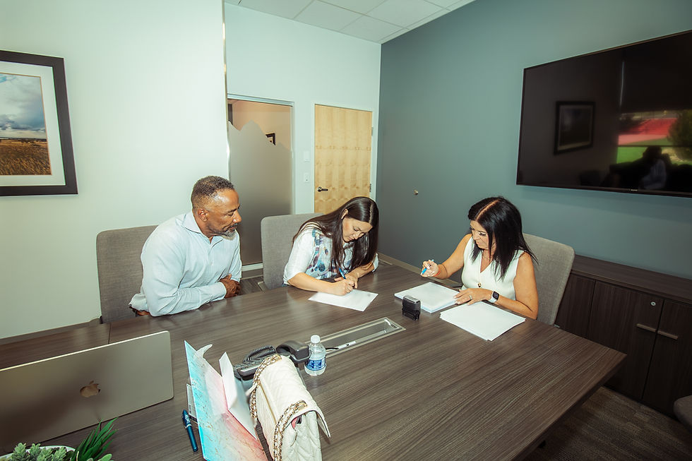 marc thomas sitting in conference room with two women signing documents