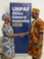 Two people in traditional attire shaking hands at UNPAF Africa.