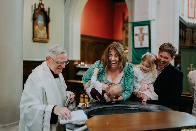 christening in church, family laughing
