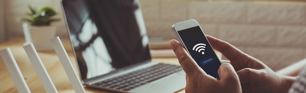 closeup of a wifi router and a man using smartphone on living room at home ofiice.jpg