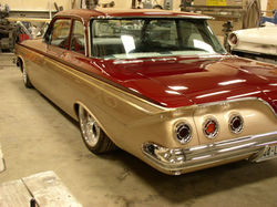 Back quarter of the freshly painted 1961 Impala showing custom moldings and taillights in place
