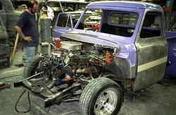 Tech looks over engine and metal work on 1954 Ford F100