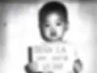 Saul Tran Cornwall as a toddler, holding a sign with his name and date of birth at the orphanage he was evacuated from in Vietnam in April 1975 [Courtesy of Saul Tran Cornwall]