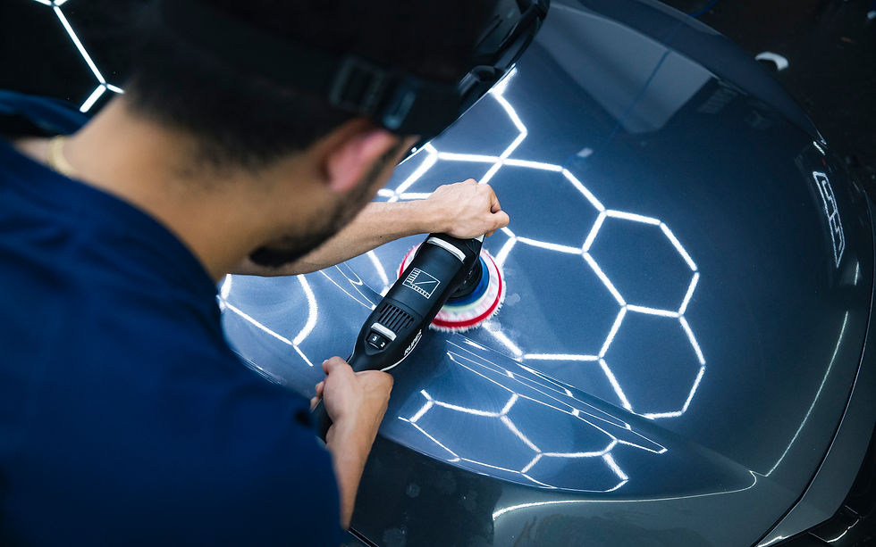 man cleaning front end of bmw