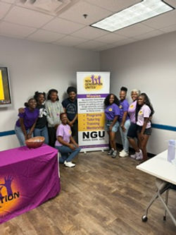 New Generation United students and volunteers gathered at the NGU mission banner