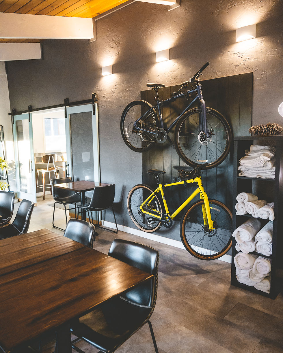 bike rack and mountains bikes on wall with towels and dining seating.