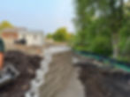 Engineered block retaining wall installation with drainage system in Dartmouth, Massachusetts by Breeze Landscape & Design serving Bristol County homeowners.