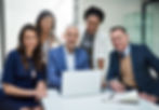 Diverse business team smiles at camera with laptop