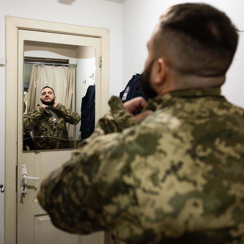 Ukrainian soldier adjusting uniform, mirror reflection